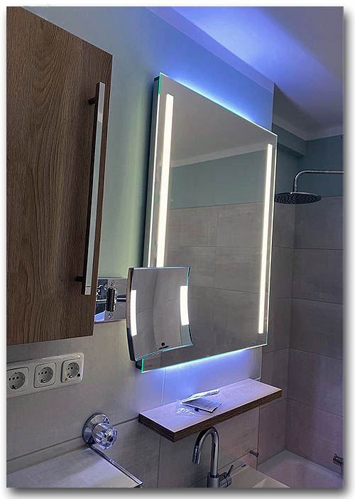 Lichtspiegel im Badezimmer mit vertikaler Spiegelbeleuchtung und zusätzlicher Raumbeleuchtung nach oben und unten mit LED als Lichtquelle